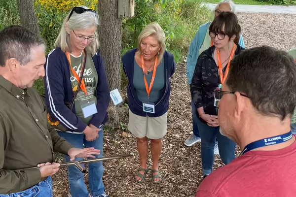 People observe a hands-on soil sampling demonstration during an Illinois Extension training.