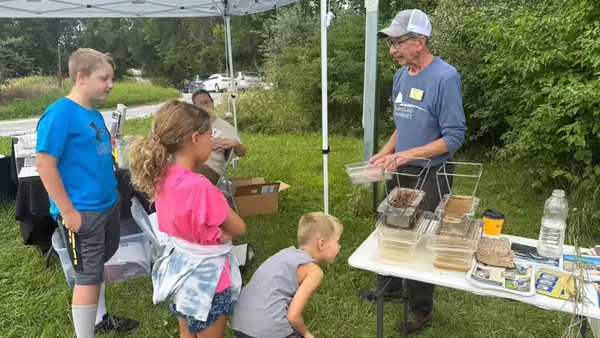 man giving demonstration outdoors to three youth