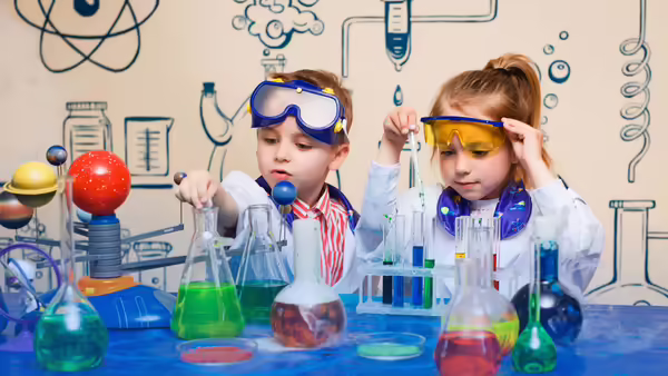 a young boy and girl dressed as scientists near scientific equipment