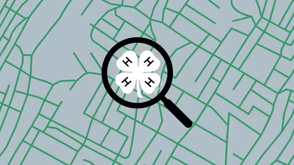 A green map with a magnifying glass with a white 4-H clover inside.