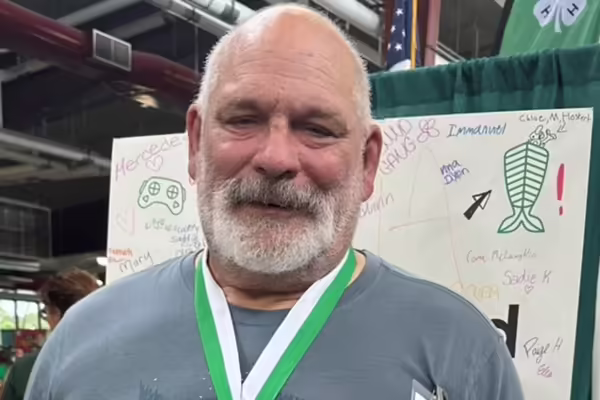 A head and shoulder shot of Dr. John Shar, a white man with gray hair and bread wearing a gray t-shirt.