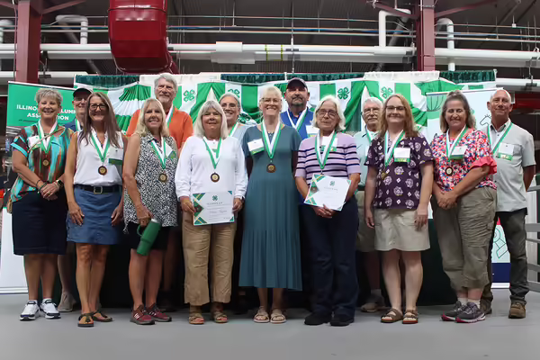 group of people standing in front of a 4-H backdrop