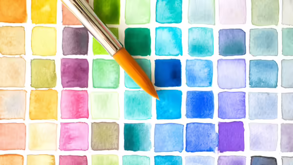 a rainbow of watercolor painted squares and a paintbrush