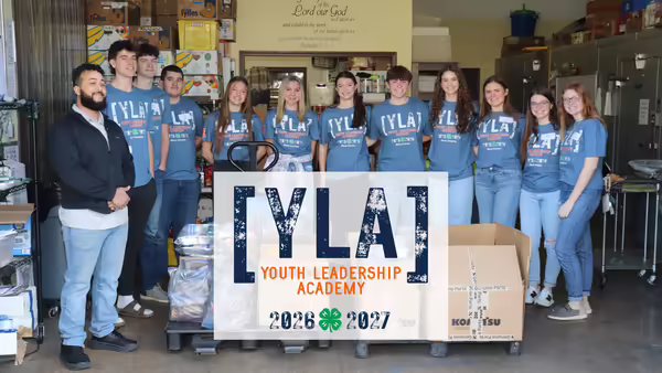 2025-2026 YLA participants pose for a photo with donated food items for Horizons Food Pantry.