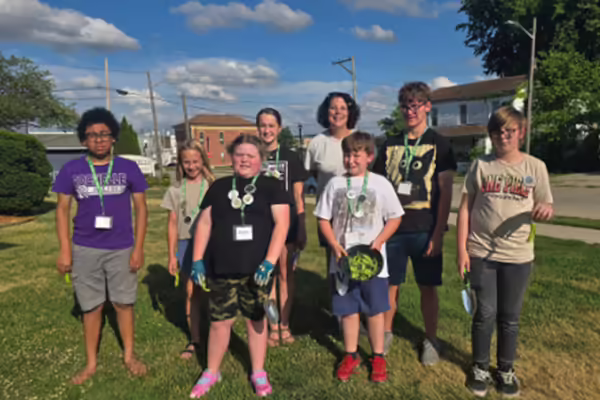 Group of youth standing outside on grass smiling