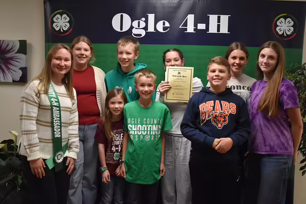 Group of youth standing with certificate.