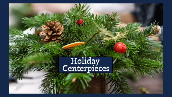 Table centerpiece made of pine boughs, pine cones, berries and orange slices.