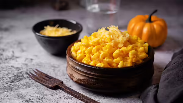 Creamy pumpkin mac and cheese in a bowl on a table.