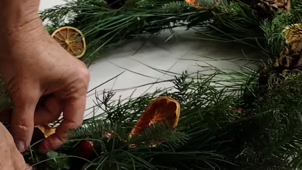 person making wreath from natural materials