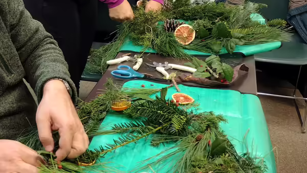person making wreath from natural materials