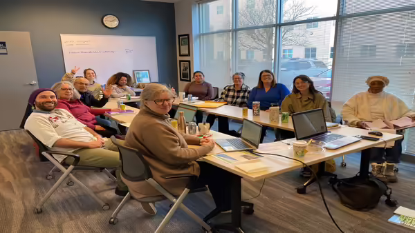 group of people sitting around open Square tables in office