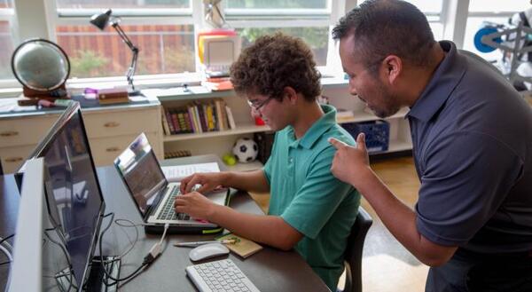 Teacher engaging with student with laptop