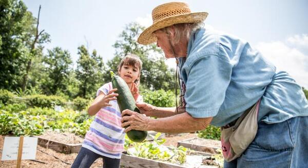 A senior citizen with a child in a garden