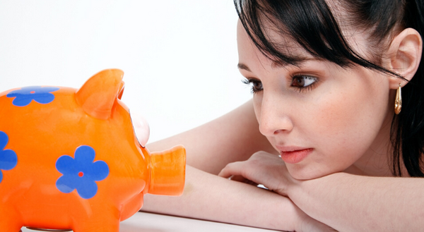 woman looking at piggy bank 