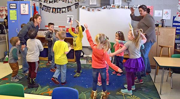 preschoolers dancing with their teachers