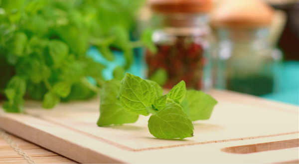 Image of fresh oregano on a wooden cutting board with blurry background
