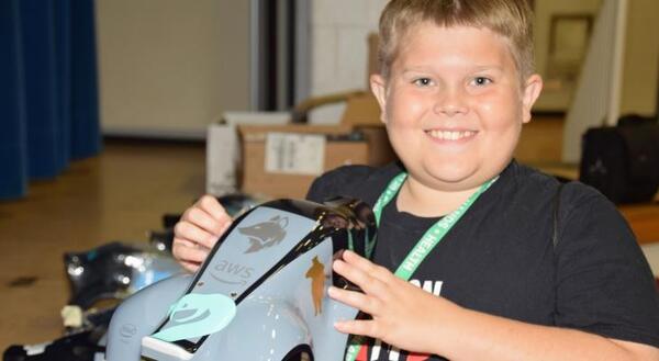 young boy holding AWS robotic car shell
