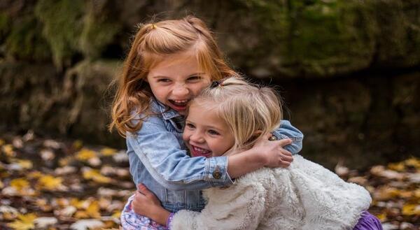 Two young girls hugging and laughing