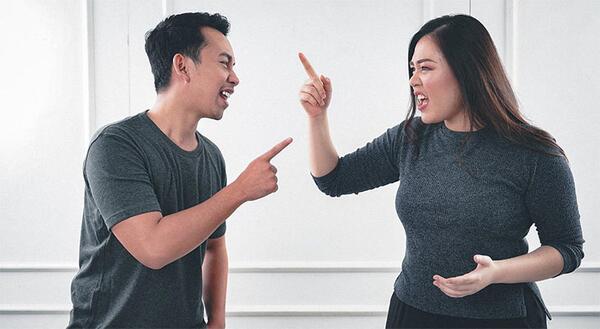 man and woman pointing at each other and yelling
