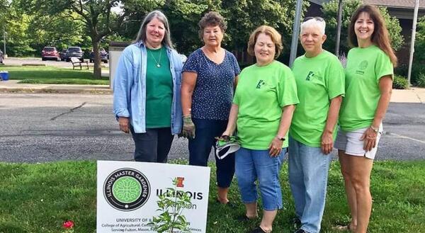 Extension Master Gardeners standing by flower bed