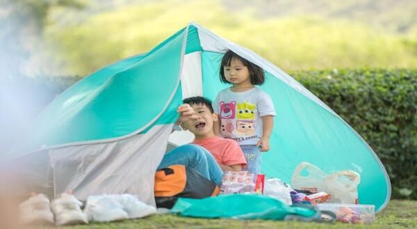 children outside of tent in backyard