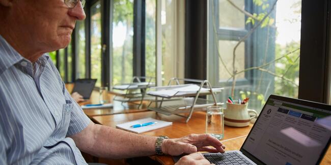 A person sitting and working from a laptop computer.