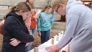 An ambassador shows younger members spices.