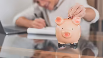 Coin being added to a piggy bank