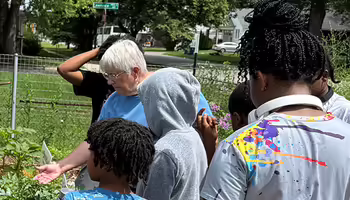 a volunteer points out plants to a group of youth