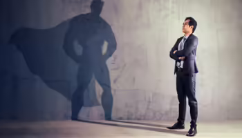 business man seeing shadow of himself with a cape