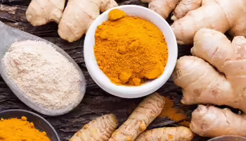 Turmeric and thumbs of ginger on a table. 