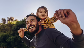 child on adult's shoulders