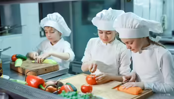 3 young children chopping vegetables 