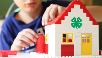 Child building a house with lego bricks