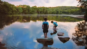 2 children exploring a pond 