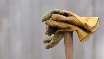 a pair of work gloves on a shovel handle