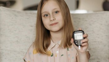 girl holding glucose monitor