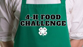 A chef wearing a green apron with the text "4-H Food Challenge" on the middle of the apron with a white 4-H clover underneath the text.