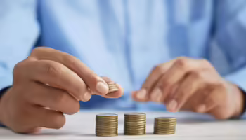 hands stacking gold coins