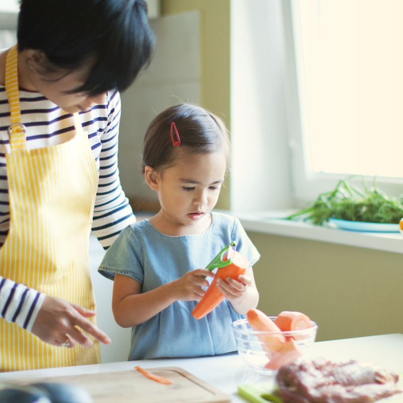 An adult teaching a child how to cook