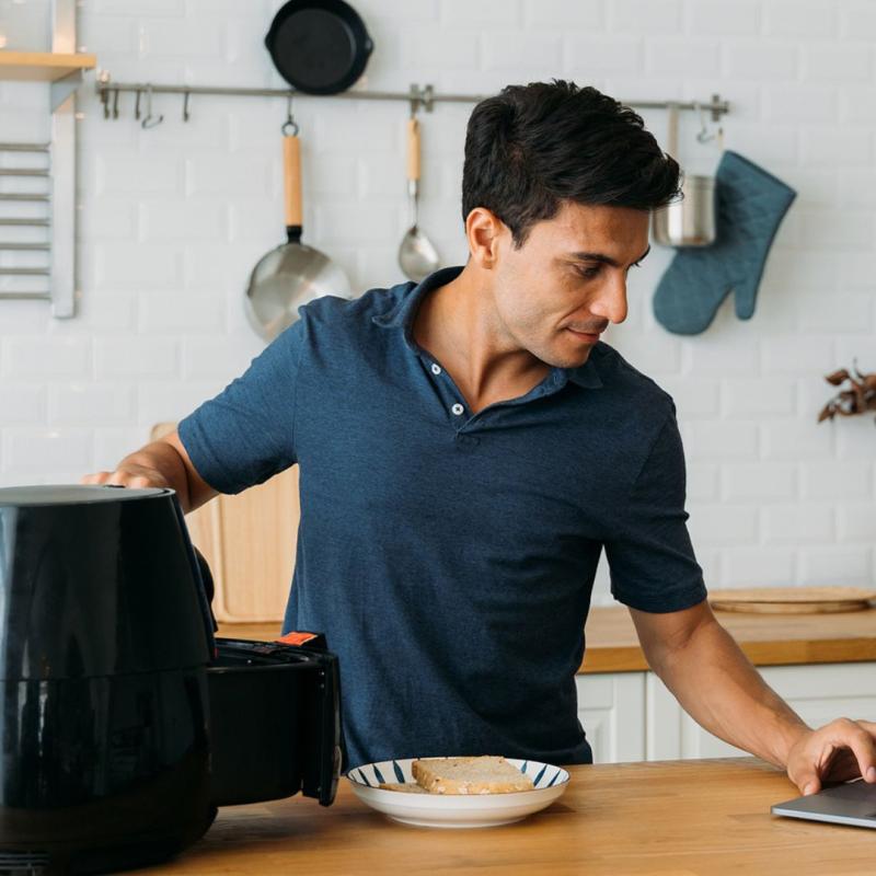 Man looking up air fryer recipes on a laptop