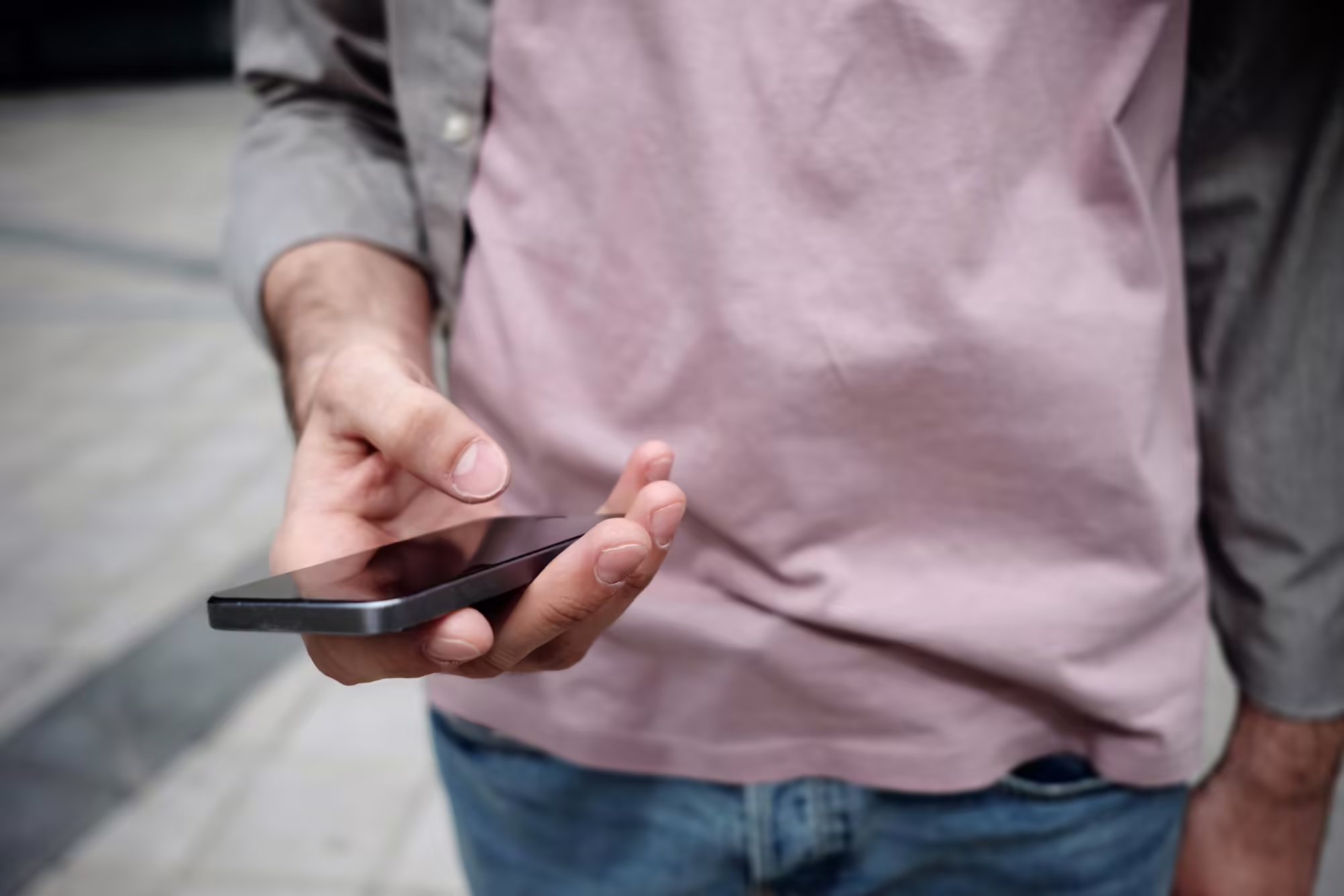person holding cellphone with pink shirt on