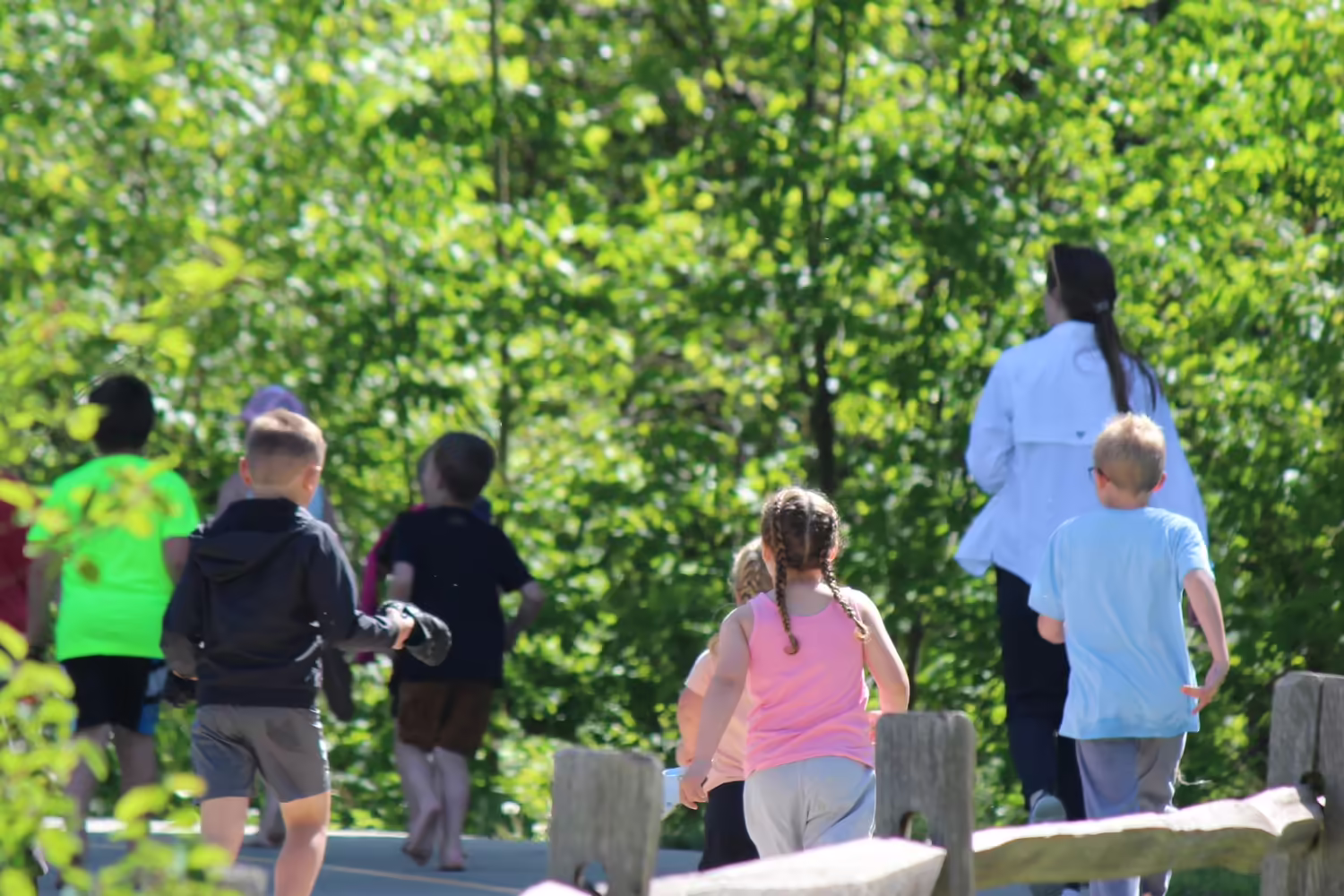 Staff lead children down a beautifully wooded trail