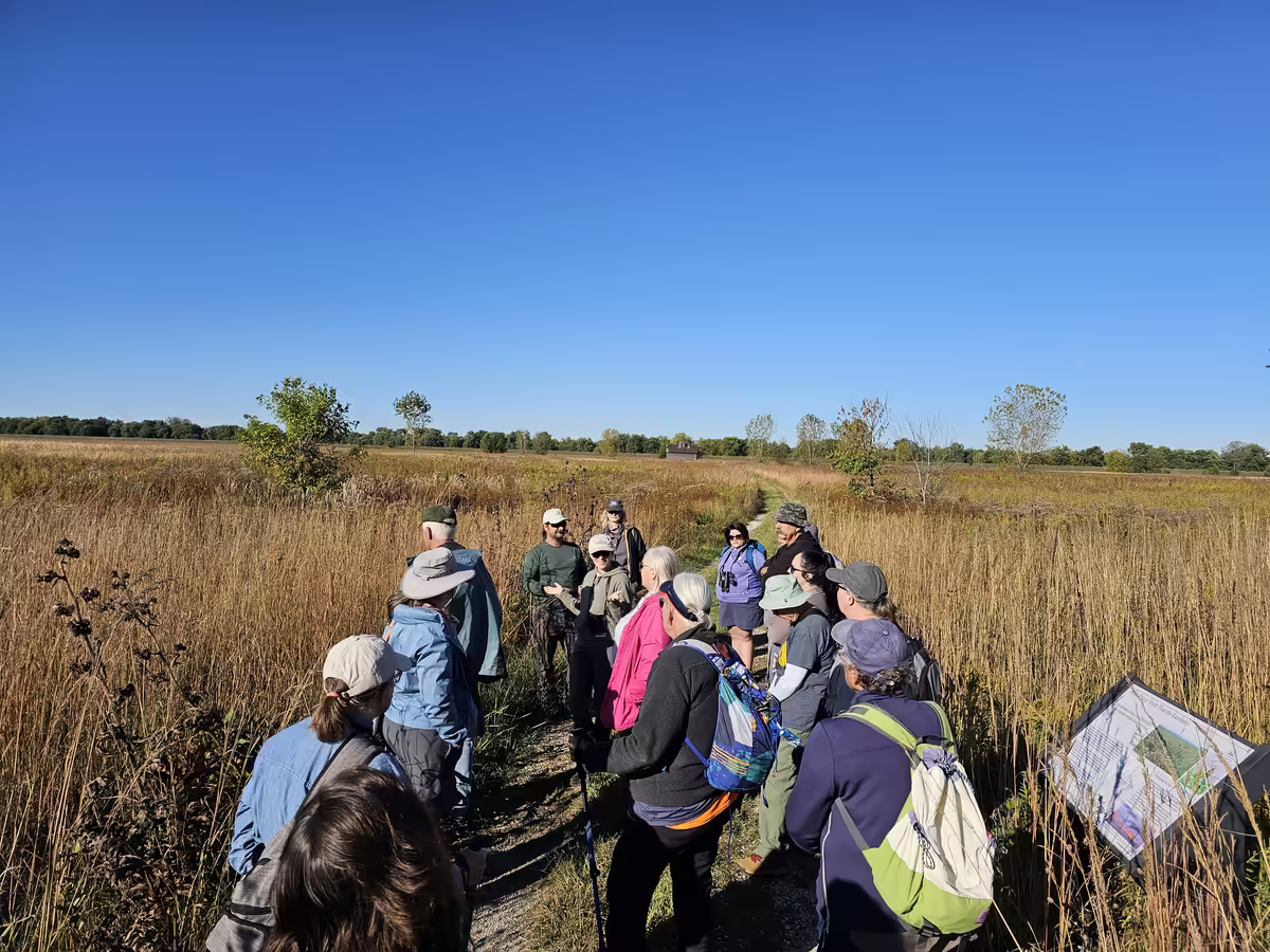 Group of people walking through the prairie.