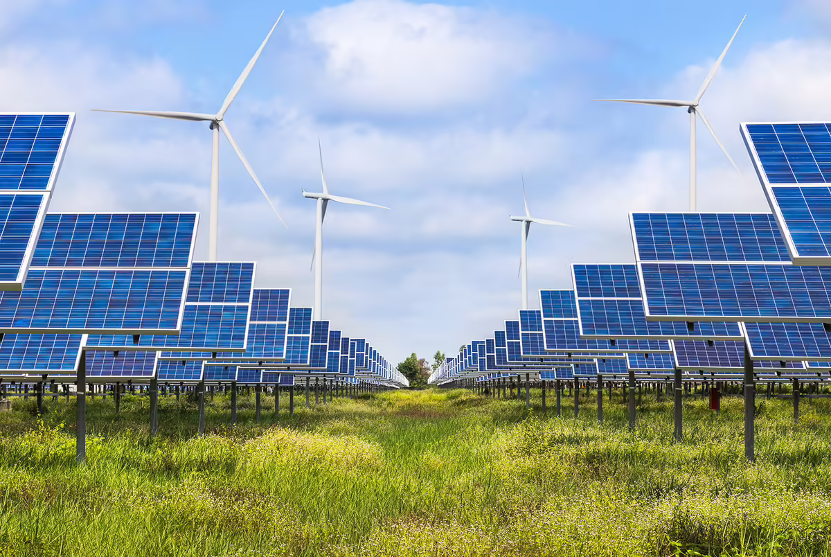 A field of solar panels and wind turbines