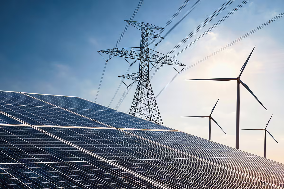 Solar panels, next to a wind turbines and power lines