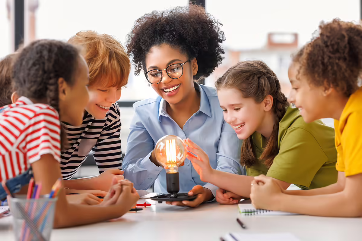 Children gathered around a lit lightbulb