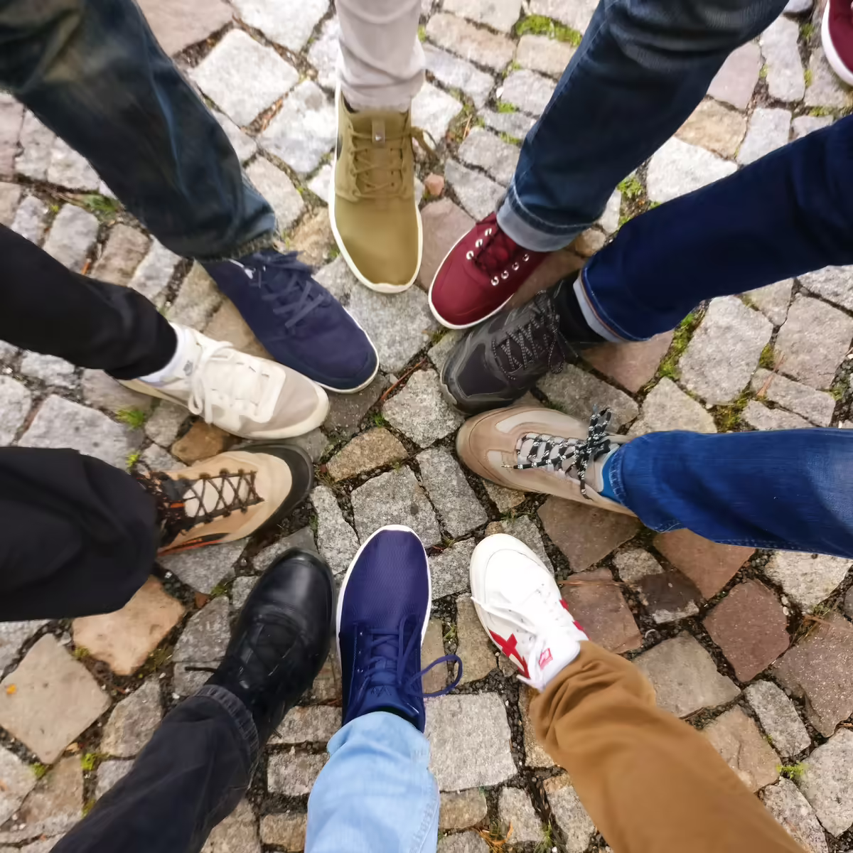 people extending one foot to form a circle of feet