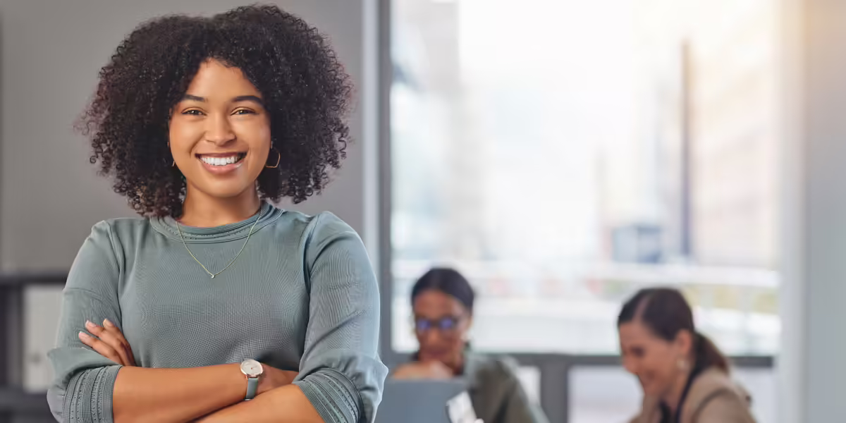 smiling young woman withcrossed arms at a workplace
