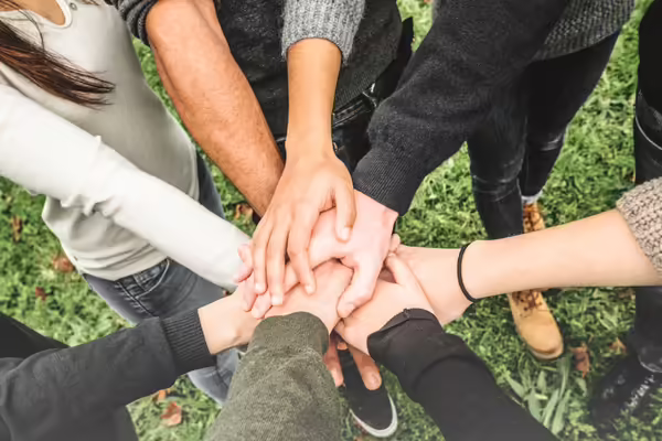 A group of people's hands joined in the center.